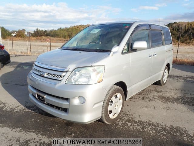 A grey JDM sports car speeding down a highway at night.