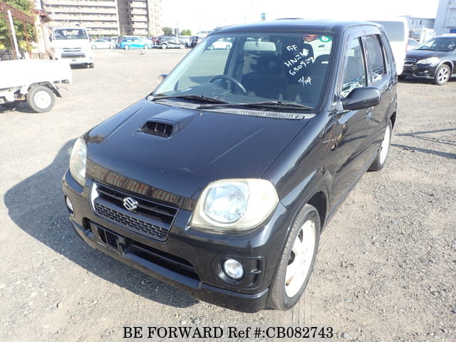 A grey JDM sports car speeding down a highway at night.