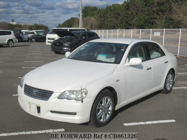 A grey sports car speeding down a highway at night.
