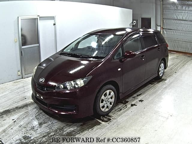 A grey sports car speeding down a highway at night.