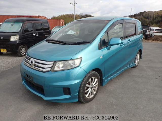 A grey sports car speeding down a highway at night.