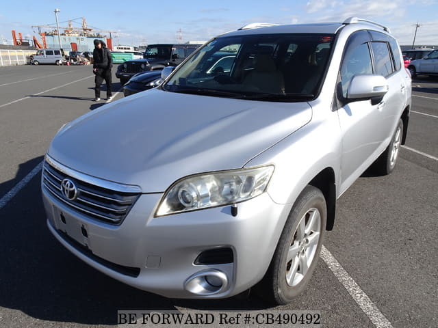 A grey JDM sports car speeding down a highway at night.