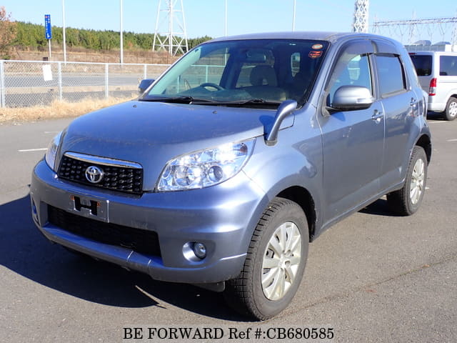A grey JDM sports car speeding down a highway at night.