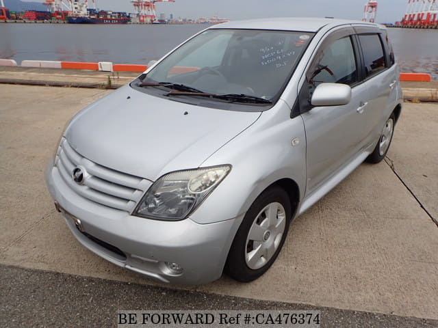 A grey JDM sports car speeding down a highway at night.