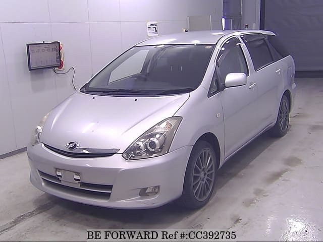 A grey sports car speeding down a highway at night.