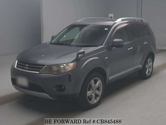 A grey JDM sports car speeding down a highway at night.