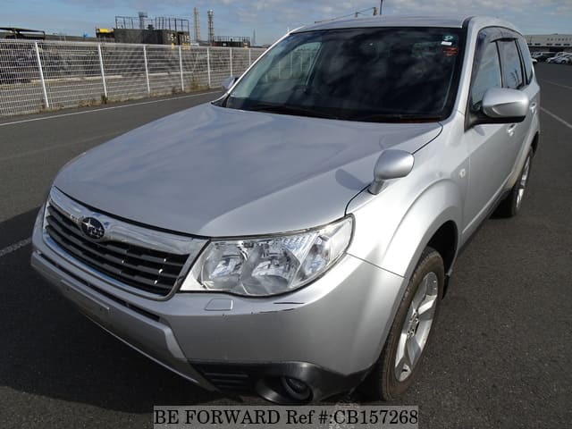 A grey JDM sports car speeding down a highway at night.