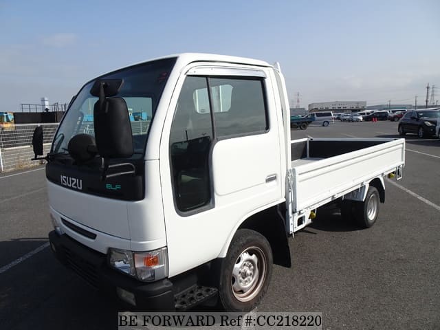 A grey sports car speeding down a highway at night.
