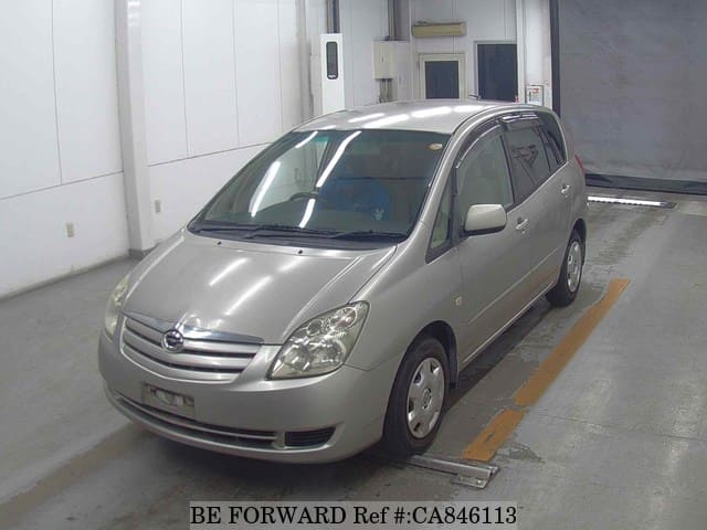 A grey JDM sports car speeding down a highway at night.