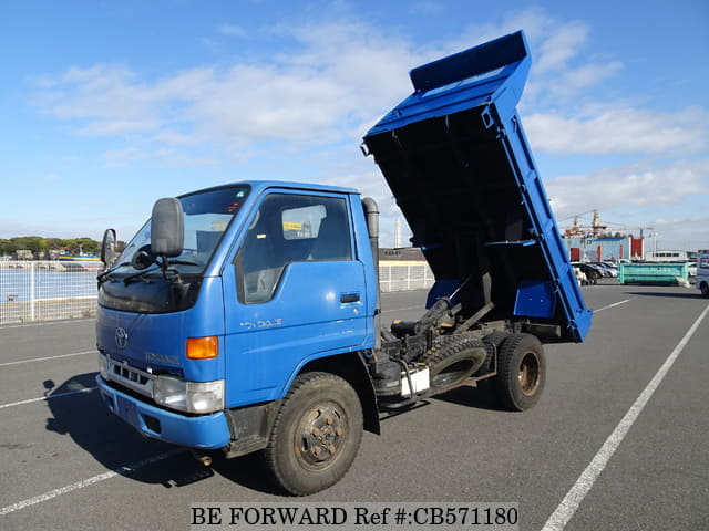 A grey JDM sports car speeding down a highway at night.