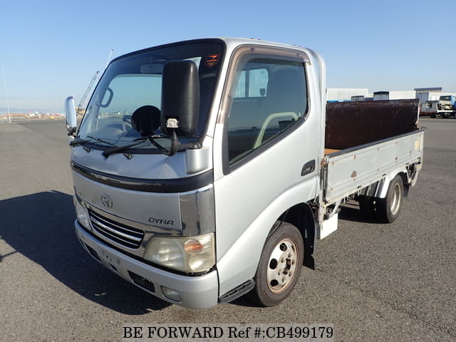 A grey JDM sports car speeding down a highway at night.
