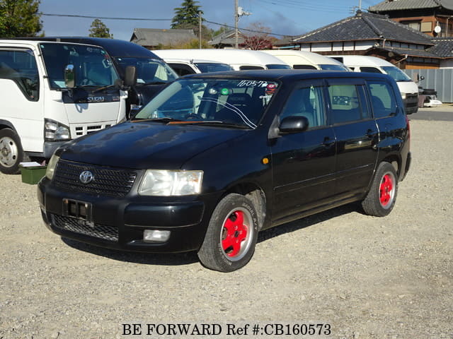 A grey JDM sports car speeding down a highway at night.