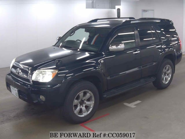 A grey sports car speeding down a highway at night.