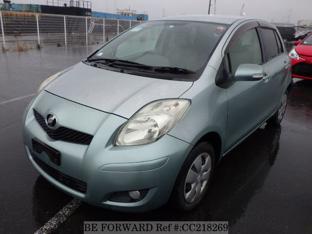 A grey sports car speeding down a highway at night.