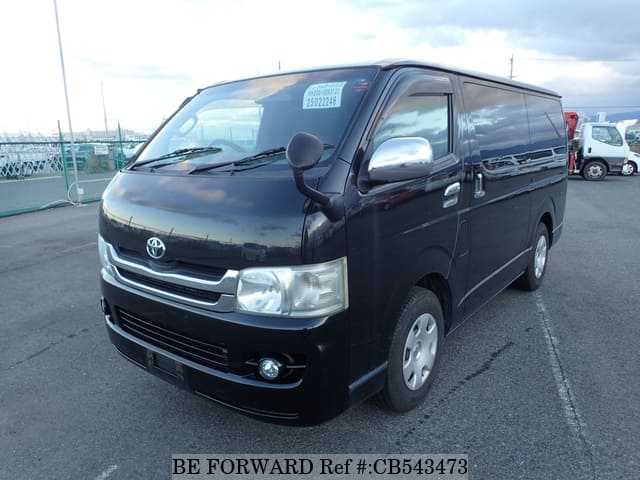 A grey sports car speeding down a highway at night.