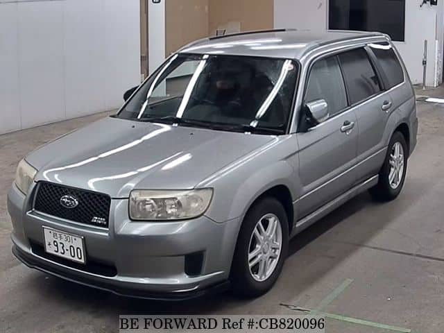 A grey JDM sports car speeding down a highway at night.