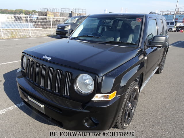 A grey JDM sports car speeding down a highway at night.