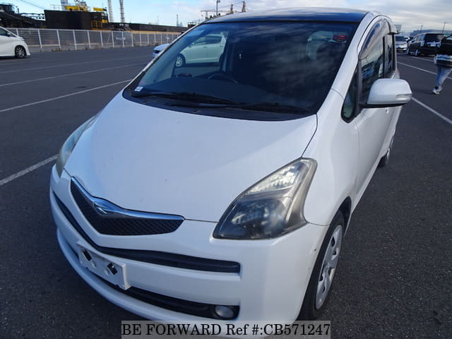 A grey JDM sports car speeding down a highway at night.