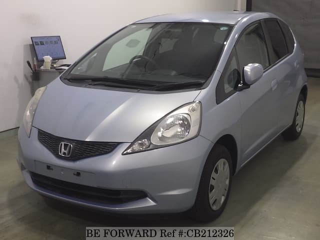 A grey JDM sports car speeding down a highway at night.