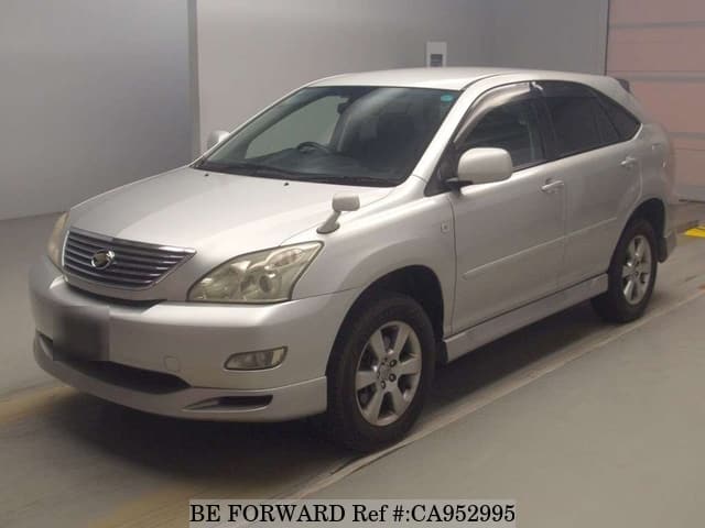 A grey sports car speeding down a highway at night.
