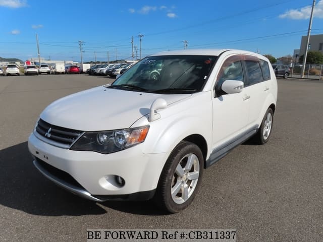 A grey JDM sports car speeding down a highway at night.