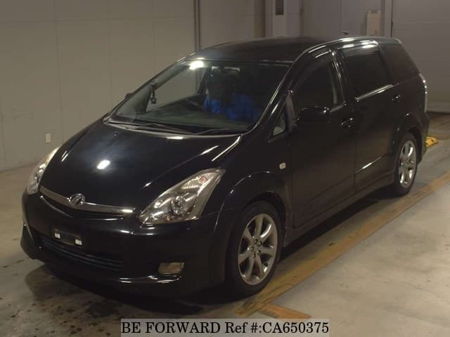 A grey JDM sports car speeding down a highway at night.