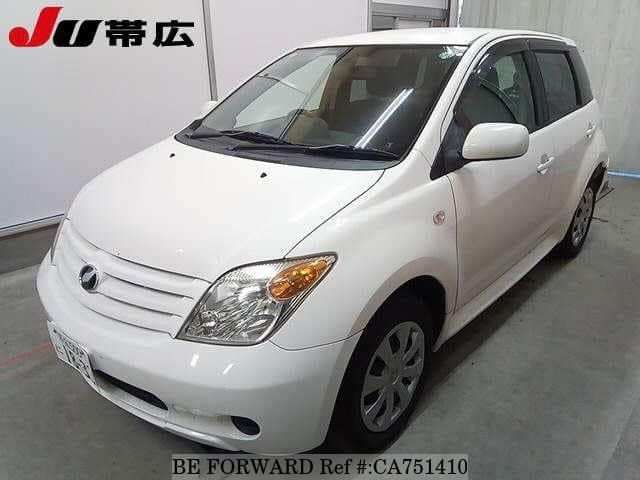 A grey JDM sports car speeding down a highway at night.