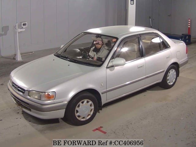 A grey sports car speeding down a highway at night.
