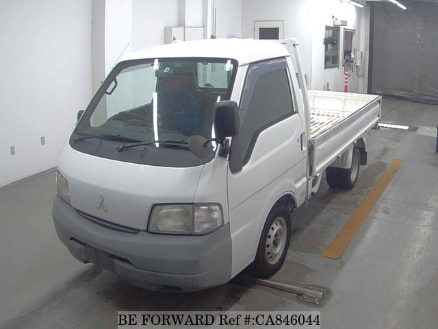A grey JDM sports car speeding down a highway at night.