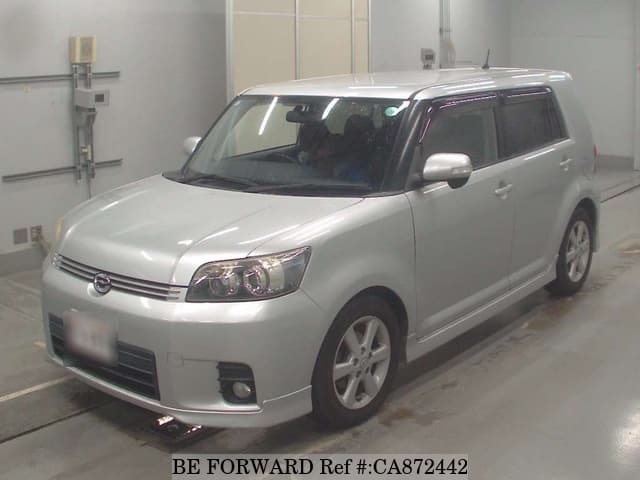A grey JDM sports car speeding down a highway at night.