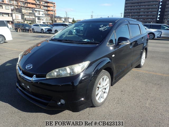 A grey JDM sports car speeding down a highway at night.