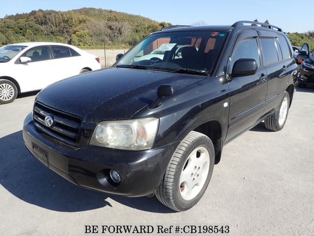 A grey sports car speeding down a highway at night.