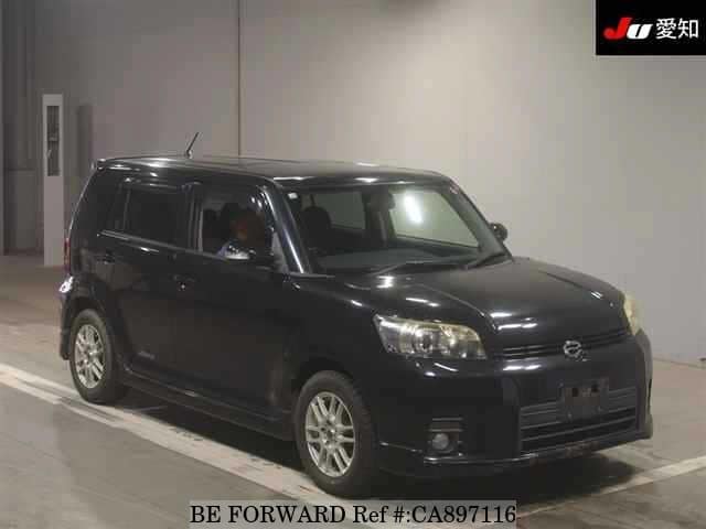 A grey JDM sports car speeding down a highway at night.