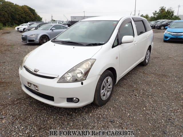 A grey JDM sports car speeding down a highway at night.