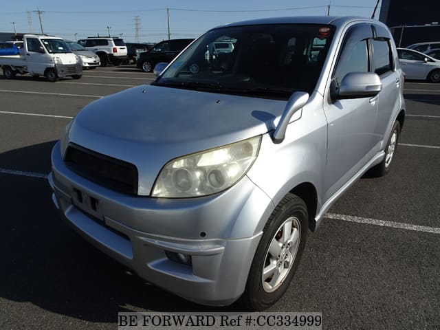 A grey sports car speeding down a highway at night.