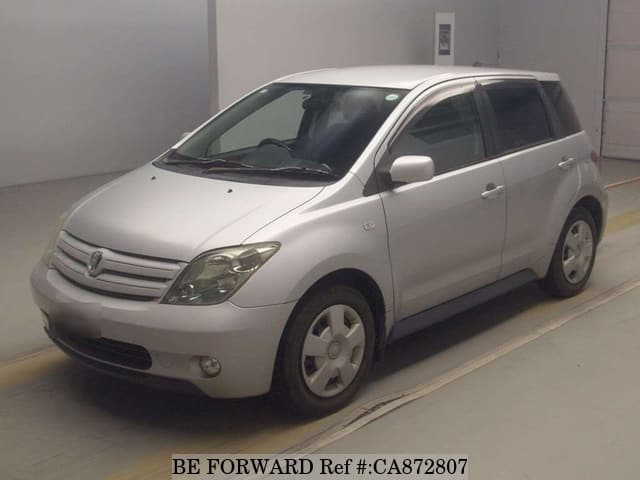 A grey JDM sports car speeding down a highway at night.