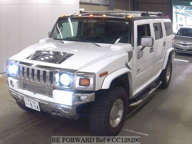 A grey sports car speeding down a highway at night.