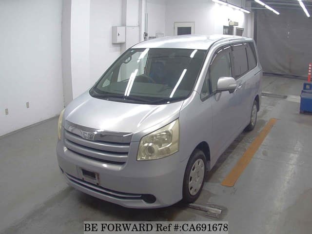 A grey JDM sports car speeding down a highway at night.