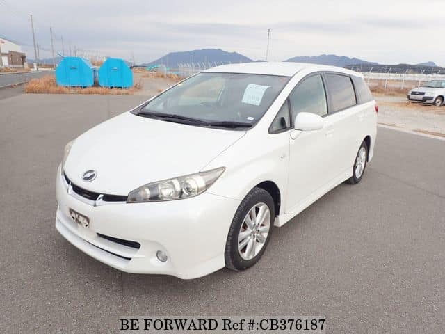 A grey JDM sports car speeding down a highway at night.