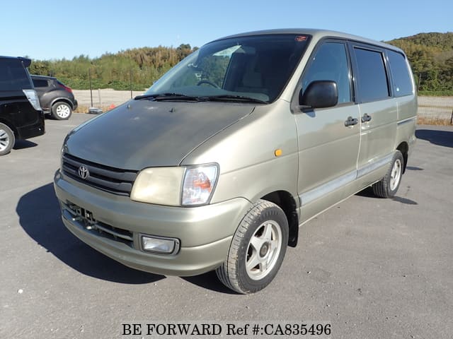 A grey JDM sports car speeding down a highway at night.