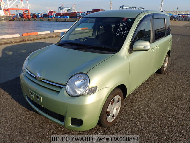 A grey JDM sports car speeding down a highway at night.