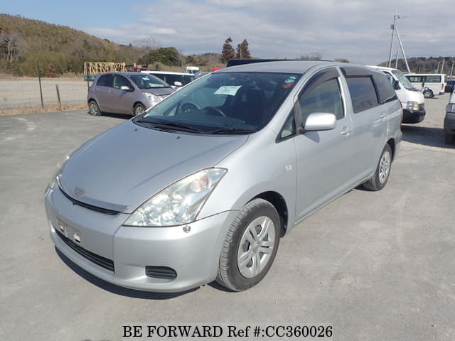 A grey sports car speeding down a highway at night.