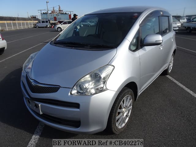 A grey JDM sports car speeding down a highway at night.