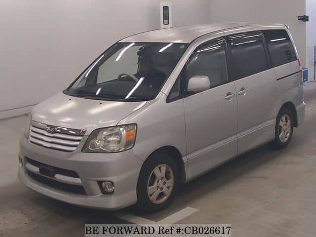 A grey JDM sports car speeding down a highway at night.