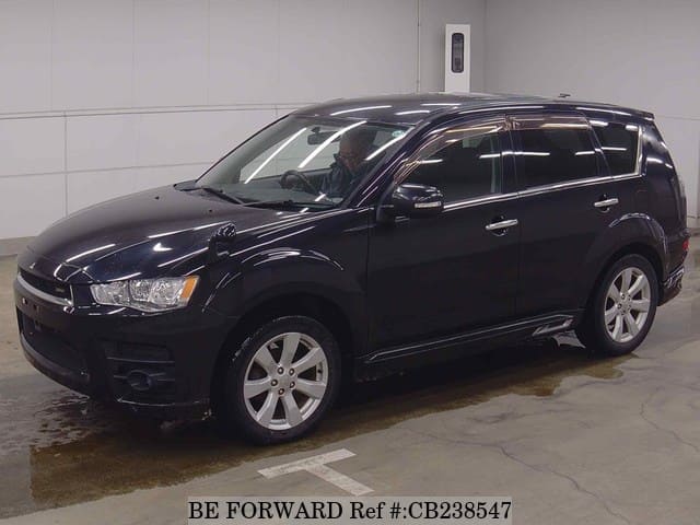 A grey JDM sports car speeding down a highway at night.