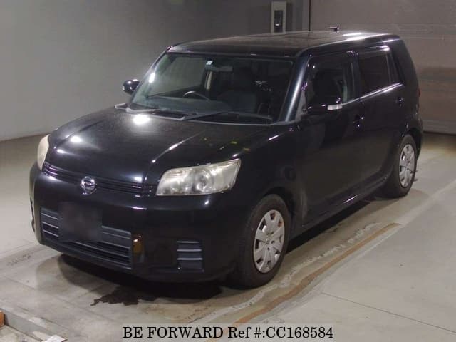 A grey sports car speeding down a highway at night.