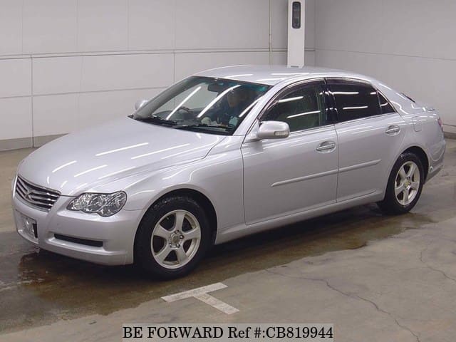 A grey JDM sports car speeding down a highway at night.