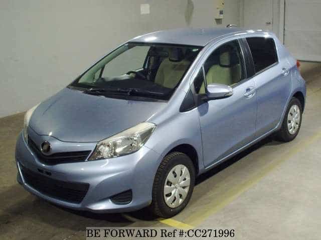 A grey sports car speeding down a highway at night.