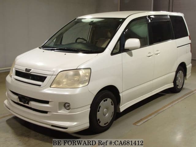 A grey JDM sports car speeding down a highway at night.