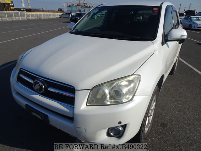 A grey JDM sports car speeding down a highway at night.